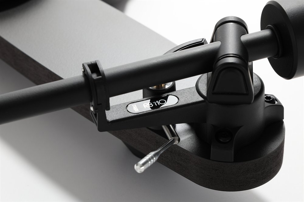 Close-up of the RB110 tonearm on the Rega Replay: the bearing housing, arm lift and counterweight in matt black.