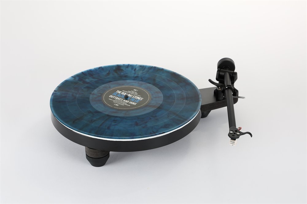 The Rega Replay in matt black from the front, a marbled blue record on the platter, RB110 tonearm with the Carbon cartridge.